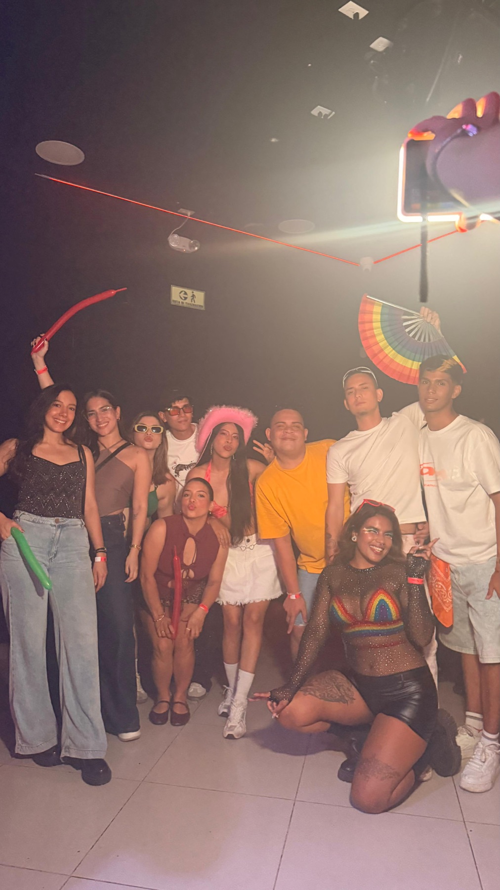 Grupo celebrando con accesorios de colores en Regia Bar Cali